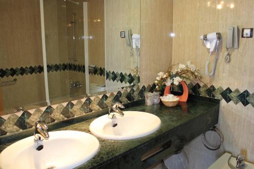 坎佩略红鸡家庭酒店的一间带两个盥洗盆和大镜子的浴室