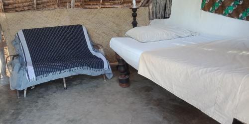 拉穆Wildebeeste Lamu的一间卧室配有两张床和椅子
