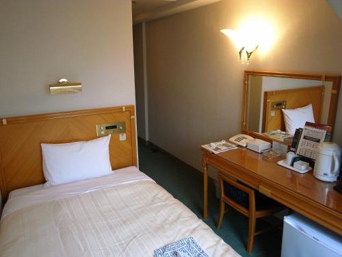 东京机山馆酒店的一间卧室配有一张床和一张带镜子的书桌