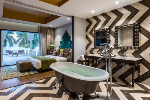 乌代浦拉肯德酒店的带浴缸的浴室和卧室