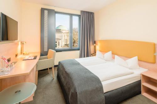 汉堡汉堡中央火车站城际酒店的配有一张床和一张书桌的酒店客房