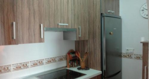 卡沃内拉斯Apartamento turístico en C/ Los Barquicos的厨房配有水槽和冰箱