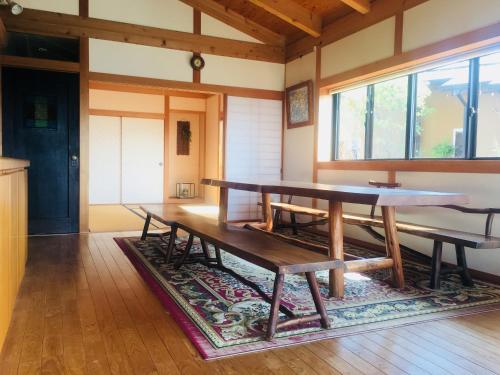四万十市Shimanto River House Yuube-Tei的一间设有桌子和长凳的地毯用餐室