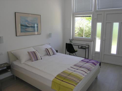 巴斯卡Apartments GORDANA Baska for relaxing holidays的一间卧室设有一张床和两个窗户。