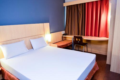 马卡帕Amapá Hotel的一间卧室配有床、椅子和红色窗帘