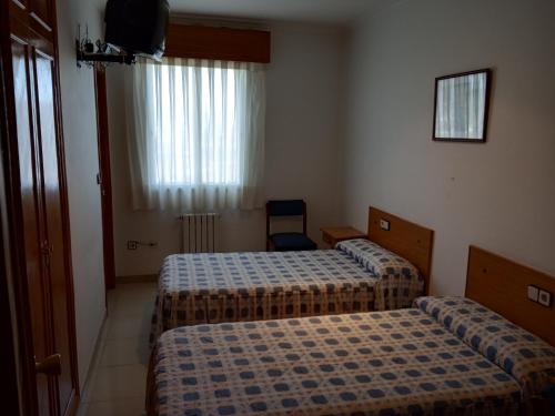 奥伦塞Hostal Mobydick2的酒店客房设有两张床和电视。