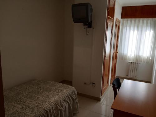 奥伦塞Hostal Mobydick2的一间小卧室,配有一张床和电视