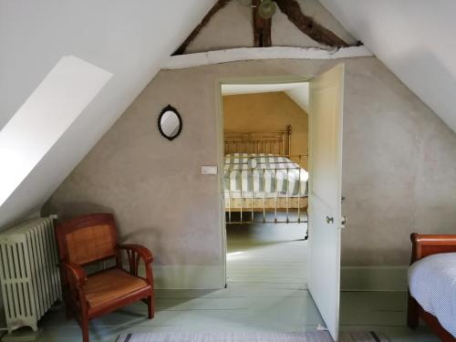 博韦La "charcuterie" GREBER的阁楼卧室配有1张床和1把椅子