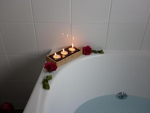 罗托鲁瓦芬顿行政酒店的蜡烛坐在玫瑰浴缸的顶部