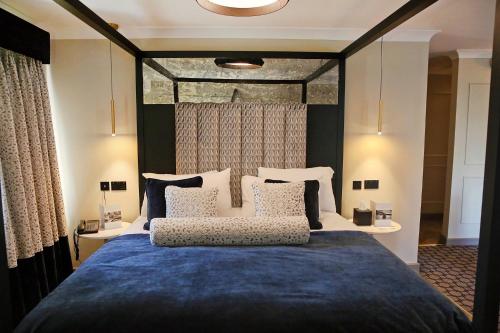 德纳姆德纳姆格鲁夫酒店的一间卧室配有一张带蓝色毯子的大床