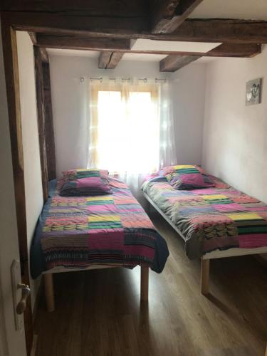 利克维Gîte Elisa et Léna的带窗户的客房内设有两张单人床。