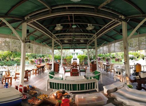 大城班銮哈恩旅馆的一间带桌椅和绿色屋顶的餐厅