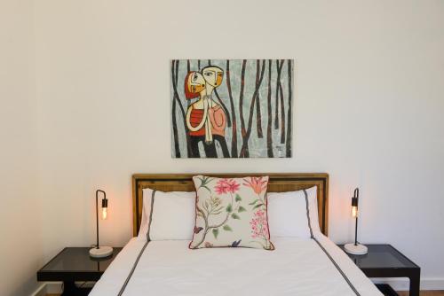 袋鼠谷Myrtle Tree Lodge - Trunks的一间卧室配有一张带两盏灯和一幅画的床铺