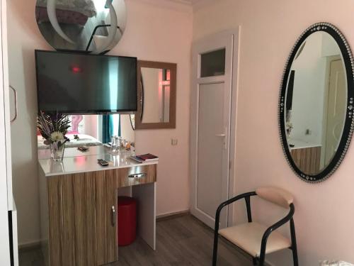 伊兹密尔因韦福酒店的客房设有带镜子的梳妆台和椅子。