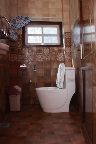 KirtipurHomestay Nepal的带浴缸、卫生间和窗户的浴室