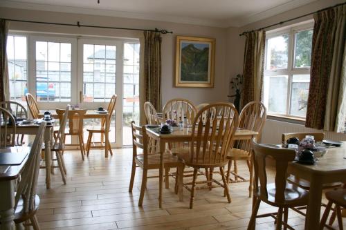 基尔肯尼Celtic House B&B的用餐室设有桌椅和窗户。