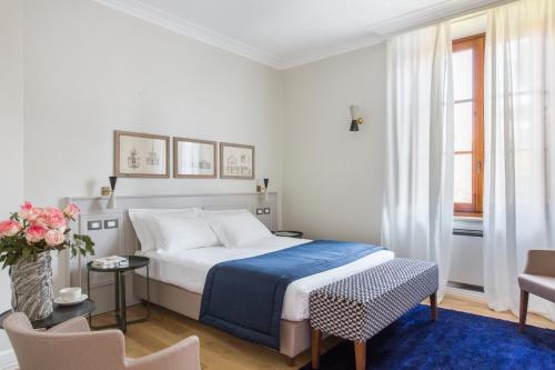 罗马Favilla Hotel di Charme的白色卧室配有床和蓝色地毯