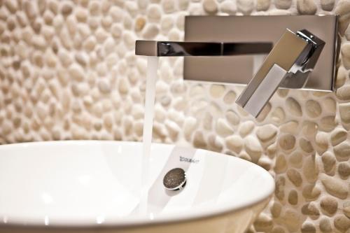 赫尔努姆54度北酒店的白色厕所,水从水龙头里流出来
