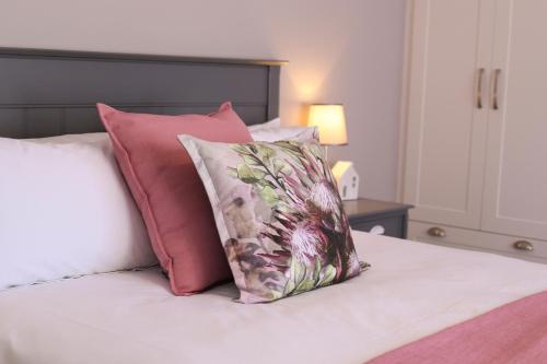 西萨默塞特Brookshill - Protea suite的床上配有粉色和白色枕头的床
