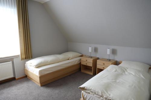 奥尔斯贝格Ferienhaus zur Sonne的一间卧室设有两张床和两个床头柜