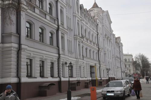 苏梅Apartment on Petropavlivs'ka 90的一座白色的大建筑,前面有一辆汽车