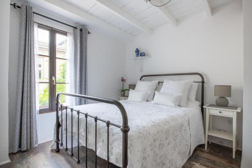 ParcoulLe Petit Bouchon的白色的卧室设有床和窗户