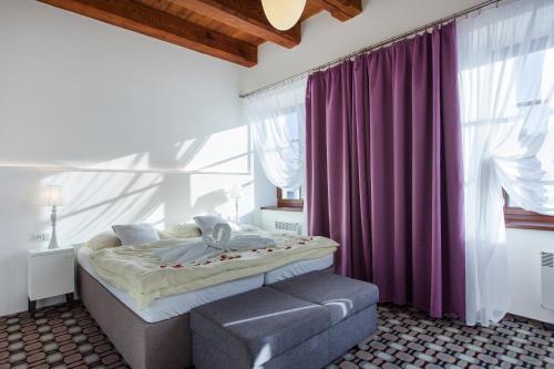 瓦尔季采塞雷特酒店的一间卧室配有一张床和紫色窗帘