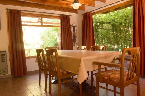 拉安戈斯图拉镇Ventana a los Cerros的一间带桌椅和窗户的用餐室