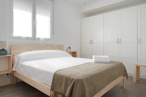 吉塔里亚BALENTZIAGA Getaria的一间卧室配有一张带白色橱柜的大床