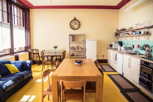 安斯特拉瑟穆雷图书库旅馆的厨房以及带桌子和沙发的客厅。