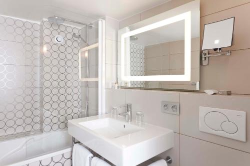 巴黎马森纳酒店的白色的浴室设有水槽和镜子