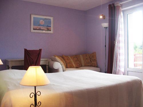 RetournacLes Frênes的一间卧室设有紫色的墙壁和一张带灯的床