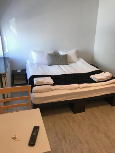雷克雅未克REK旅馆的一张位于带桌子和遥控器的房间的床铺