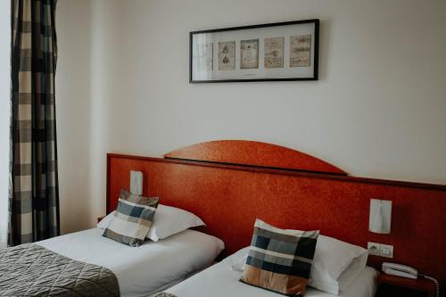 兰斯兰斯中心水晶酒店的酒店客房设有两张床,墙上挂着一张照片。