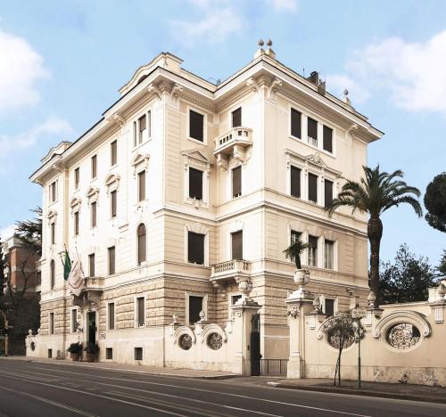 罗马阿尔德罗万迪城市套房酒店的一座白色的建筑,前面有棕榈树