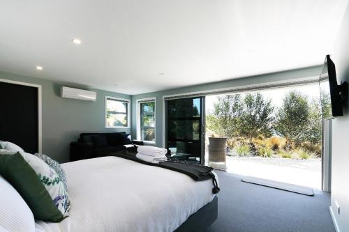 特卡波湖High Country Retreat - Lake Tekapo的一间卧室设有一张床和一个大窗户