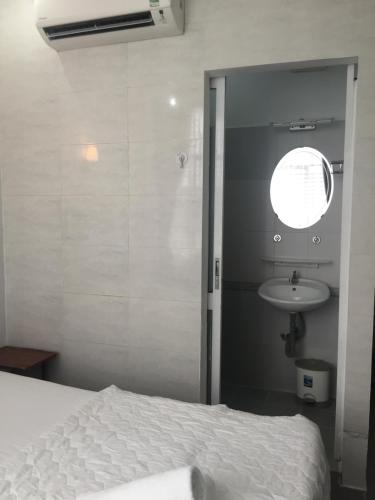 胡志明市VY庆旅馆 的卧室配有白色的床和水槽
