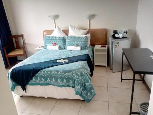 德班Concord Christian Guesthouse的一间卧室配有一张带蓝色棉被的床