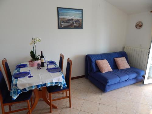 法扎纳MARILENA的一间带桌子和蓝色沙发的用餐室