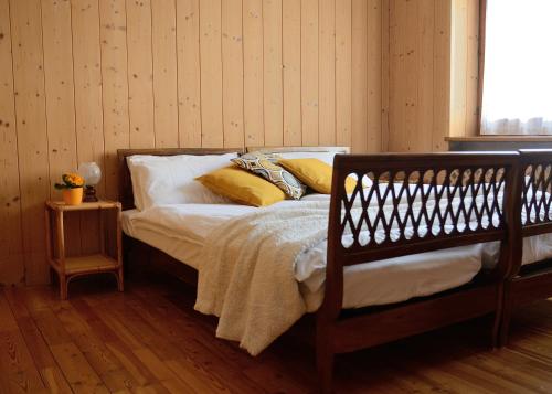 图恩诺Casa vacanze Dos de Loré - Relax a due passi da Tovel的一间卧室配有带白色床单和黄色枕头的床。