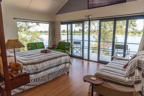 利文斯顿Kayube Boat House的一间卧室配有一张床,享有水景