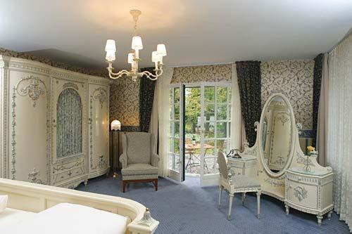沃尔普斯韦德布城霍夫酒店的一间设有镜子、一张床和椅子的房间