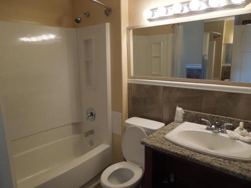 大洋城Sifting Sands Motel的一间带水槽、卫生间和镜子的浴室