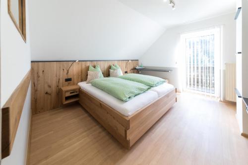 Rein斯库斯特保尔旅馆的一间卧室配有一张带绿色枕头的床。