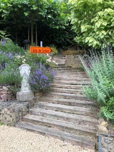 LeignonGîte de Corbion的花园,花园内有鲜花和标志的石路
