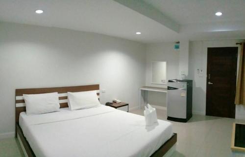 Ban Wat PaDD Boutique Resort的卧室配有一张白色大床和一台冰箱