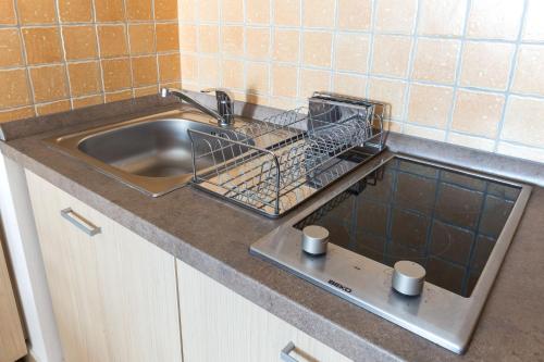 米什科尔茨MSE Apartman的厨房水槽,配有一个碗碟干燥架和两个杯子