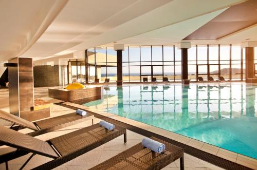 察夫塔特克罗地亚酒店的大楼内带椅子的大型游泳池