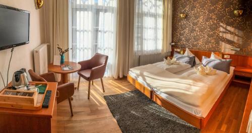安姆茨堡维里斯池别墅酒店的一间卧室配有一张床、一张桌子和一台电视