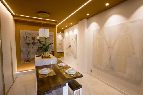 圣塞瓦斯蒂安Boulevard Luxury by Sebastiana Group的用餐室配有桌子,墙上挂有绘画作品
